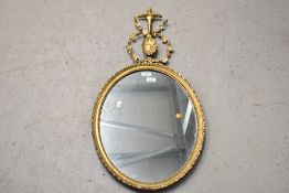A regency oval framed mirror with gilt and gesso design with floral decoration