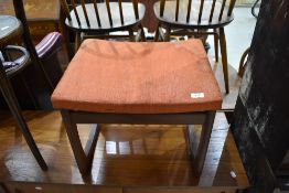 A vintage teak stool with orange seat covering, E Gomme (G plan)