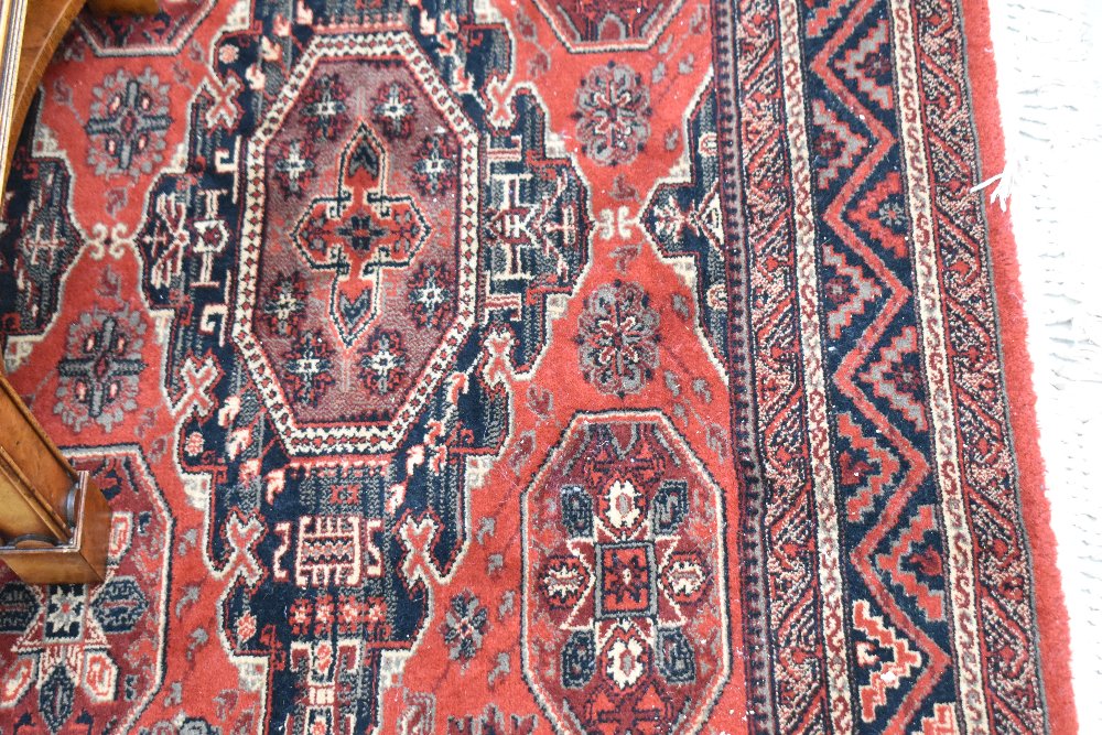 A modern carpet square of red ground with black and cream tones, approx. 236 x 171cm
