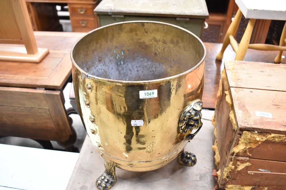 A brass coal bucket having lion mask handles and claw feet