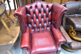 An oxblood red wing back armchair