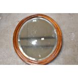 A bleached mahogany oval wall mirror