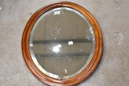 A bleached mahogany oval wall mirror