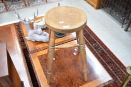 A traditional stripped stool having turned frame