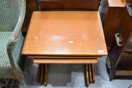 A vintage teak nest of three tables