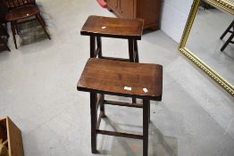 A pair of traditional dark stained wood kitchen or bar stools