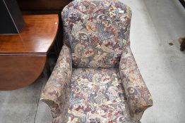 A Victorian easy chair having turned mahogany legs and later upholstery