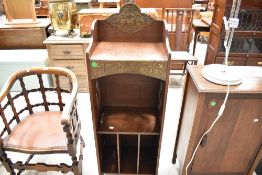 A late 19th/early 20th Century Arts and Crafts oak narrow cabinet with brass applique panels and
