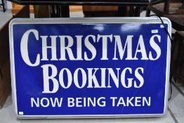 An illuminated sign, 'Christmas Bookings Now being Taken', in working order