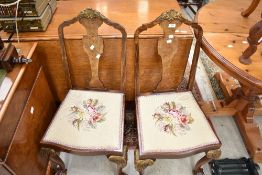A pair of early 20th Century continental style salon chairs having ball and claw feet with gilt