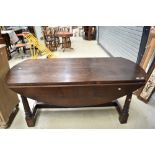 A reproduction oak banquetting style drop leaf table on chunky frame, large proportions