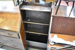 An early 20th Century oak narrow bookshelf with paper rack to lower part