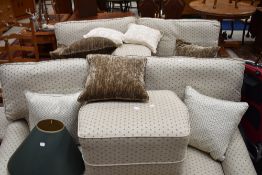 Two modern settees, of shaped form, and a matching pouffe