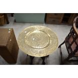 An Oriental brass top table having folding frame of typical design