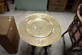 An Oriental brass top table having folding frame of typical design