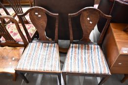 A pair of 19th Century mahogany dining chairs having shaped backs and later upholstered seats