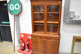 A reproduction Regency yew wood bookcase with cupboard under