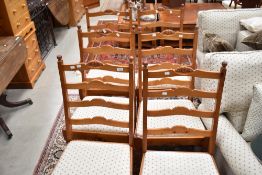 A set of six modern pine ladder back dining chairs having overstuffed seats