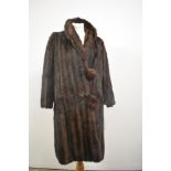 A vintage fur coat having large self covered buttons and Millers of Dundee label.