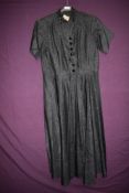A late 1940s/ early 50s black Moire taffeta day dress having Halles label, glass buttons to front,