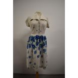 A 1940s floral linen day dress having bold blue pattern and decorative buttons to front, smocking to