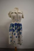 A 1940s floral linen day dress having bold blue pattern and decorative buttons to front, smocking to