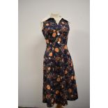 A vibrant 1960s day dress having rose pattern in orange to blue ground.