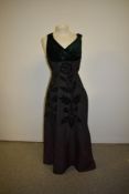 A 1950s Michael Paul model evening gown in black taffeta with green velvet appliqué pattern and