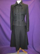 A late 1960s/70s two piece suit having frog fastening front to jacket and A line skirt with metal