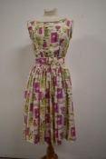 A stunning 1950s feather weight pure silk dress having novelty Geisha girl print in pink, yellow and