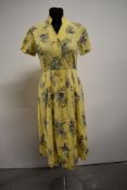 A late 1940s/ early 1950s button down yellow floral cotton shirtwaister dress.