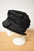 A beautiful example of a 1920s black cloche hat having bands of grosgrain between cotton sateen (