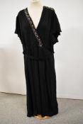 A late 1930s black crepe dress having fluted sleeves and beaded accents, belt to waist, no fastening
