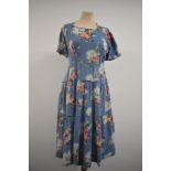 A late 1930s day dress in blue floral cotton having side metal zip, tiered skirt and square neckline