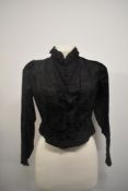 A Victorian bodice in black patterned silk or silk blend, having lace to cuffs and neck, fully boned