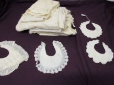 A mixed lot of antique children's clothing including embroidered bibs and dresses, also included are