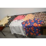 Seven vintage ladies tops and blouses in vibrant patterns, various sizes and styles.