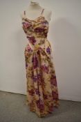 A stunning floral 1940s evening gown having pockets to front and tie belt to waist, hook and eye