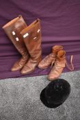 Two pairs of tan leather vintage riding boots having leather soles and a velvet riding hat, circa