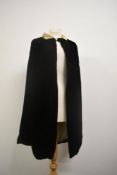 A 1920s/ 1930s opera cape in black velvet with cream velvet collar and gathered detailing to