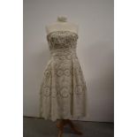 A late 1950s early 1960s cream strapless dress having sequin and diamante detailing throughout.