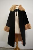 A vintage opera cape, around 1930s, in black velvet with fur collar and cuffs, lined in pink