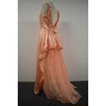 A vintage pink evening gown having peplum waist detail to back and layers of tulle lace and net.