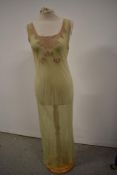 A 1930s pale green bias cut nightgown having champagne coloured lace detailing.