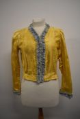 An early 20th century yellow satin jacket having hook and eye fastening to front and accented in