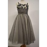 A 1950s evening dress having flocked velvet floral pattern to cream bodice and layers of black and