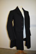 A gents Edwardian black frock coat, dated October 30th 1909, buttons to front and buttons to