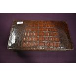 A large vintage Argentinean mahogany toned crocodile or similar clutch bag having internal pockets.