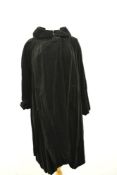A 1950s Fenwick of Bond street Fair Lady swing coat in black velvet with shawl collar and large