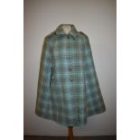 A 1960s Wetherall cape in pale blue and beige check.